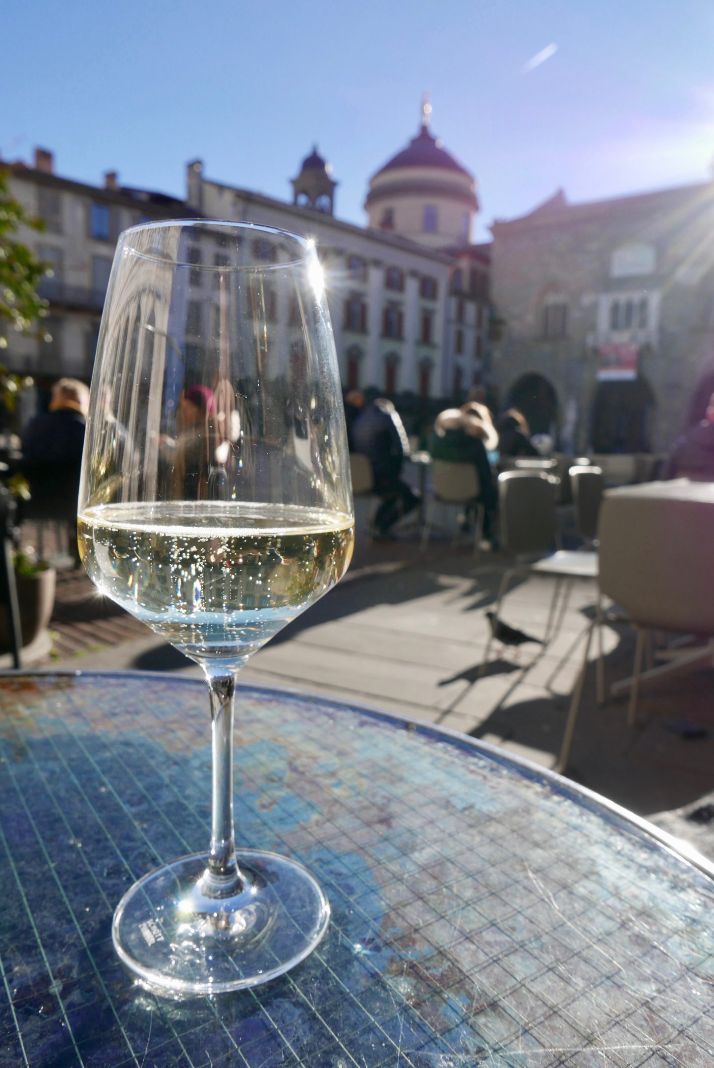 A glass of prosecco in the winter sunshine at Piazza Vecchia in Bergamo