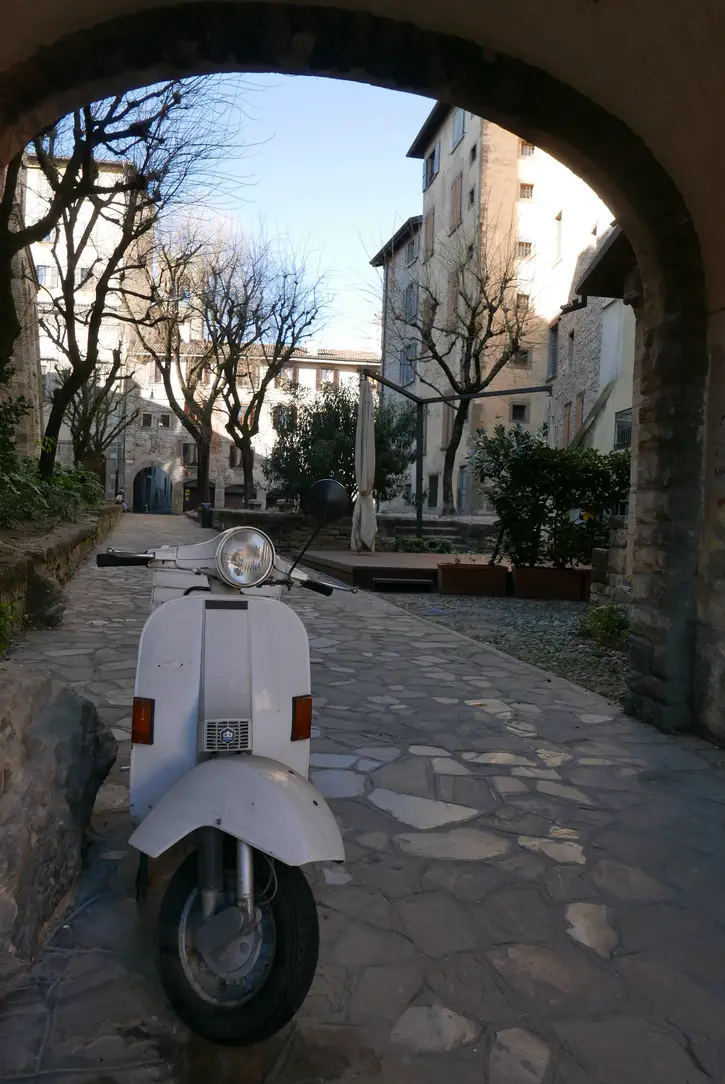 A moped parked under an arch in Bergamo Citta Alta