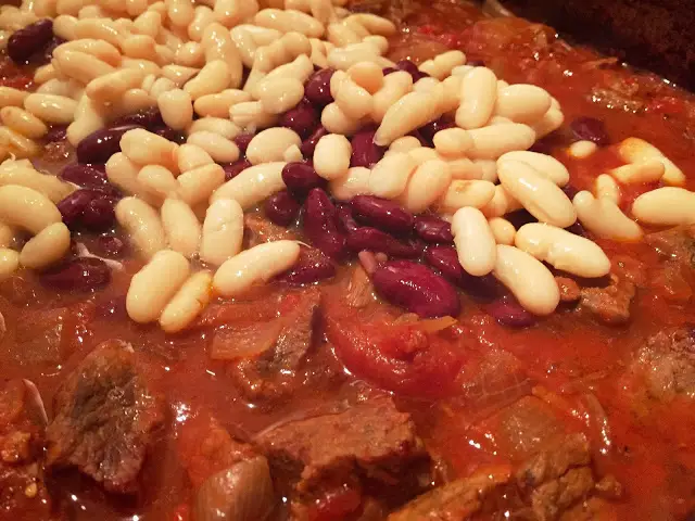 Adding the beans to the slow cooked beef chuck.