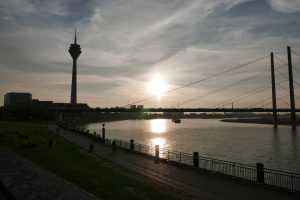 A view of the Rhine Tower with the river Rhine at sunset