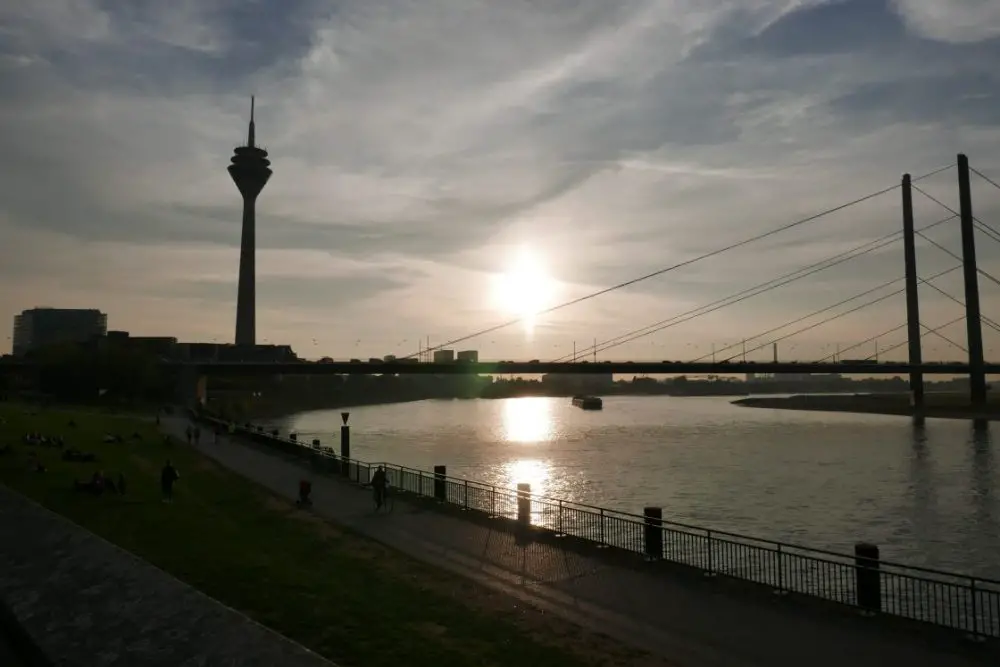 A view of the Rhine Tower with the river Rhine at sunset