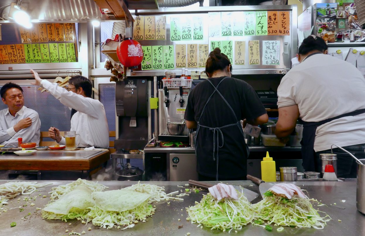 A lively evening at an Okonomiyaki bar in Okonomimura in Hiroshima