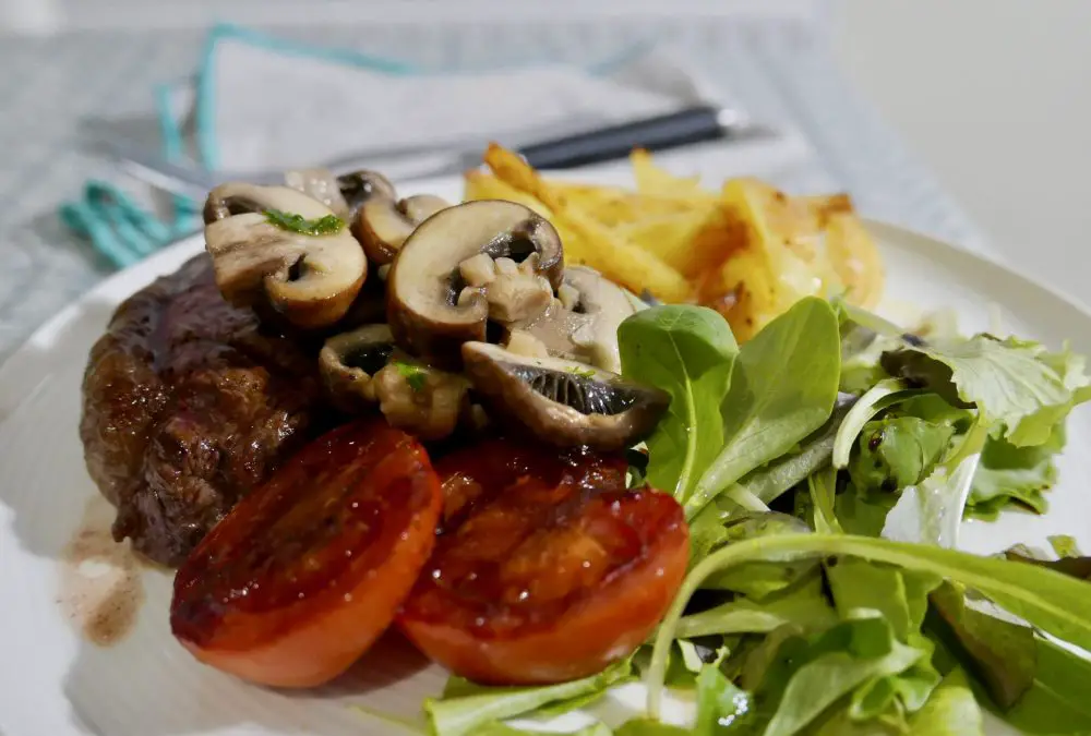 Steak and chips with tomatoes and garlic mushrooms