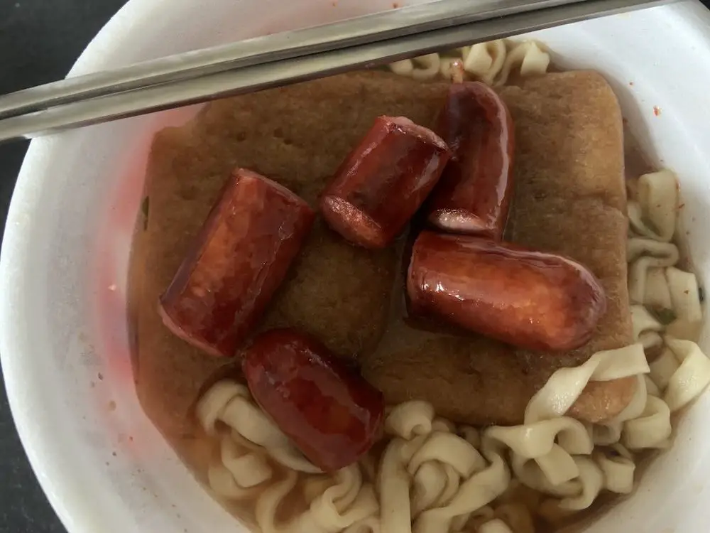 Chopped sausage in a noodle bowl