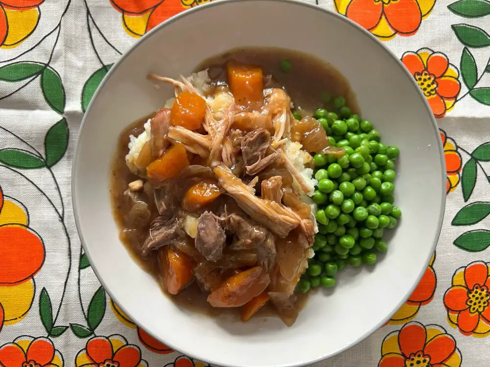 slow cooked whole pork cheek with mashd potatoes and peas