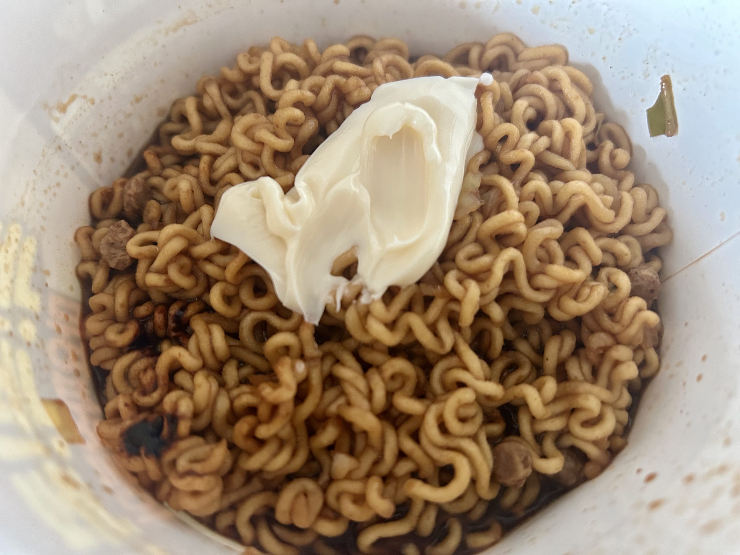 Adding the mayonnaise to the jjajang noodles 