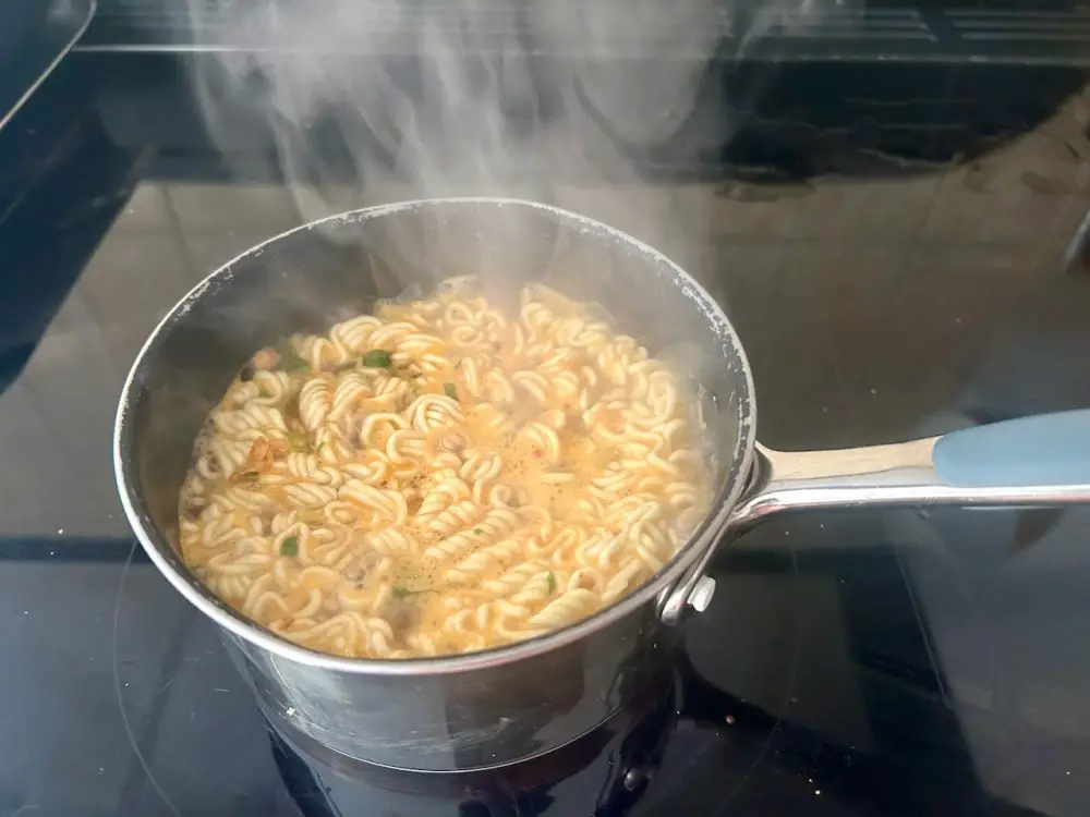 Cooking instant noodles in a pan on the hob