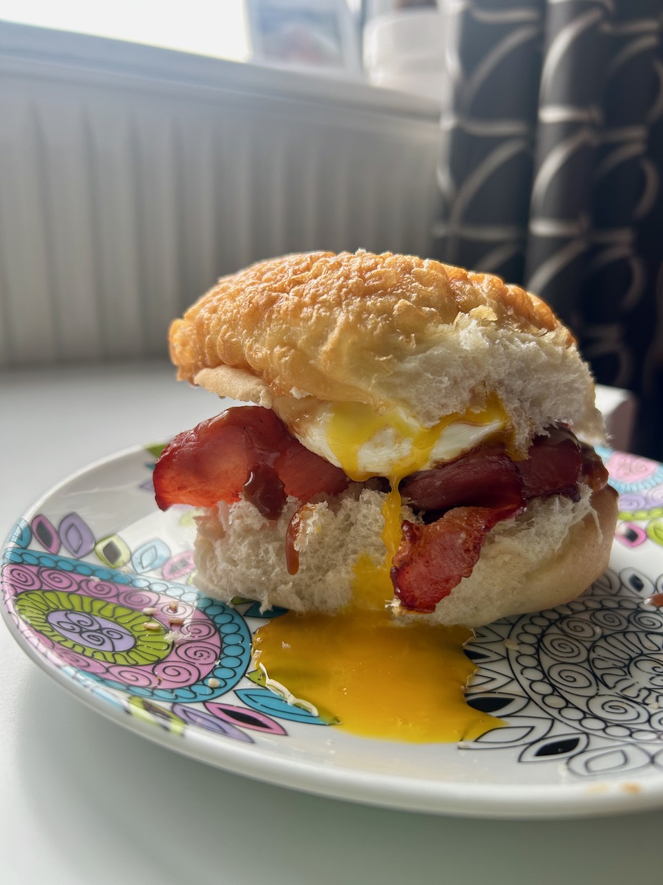 Crispy bacon and runny egg bap