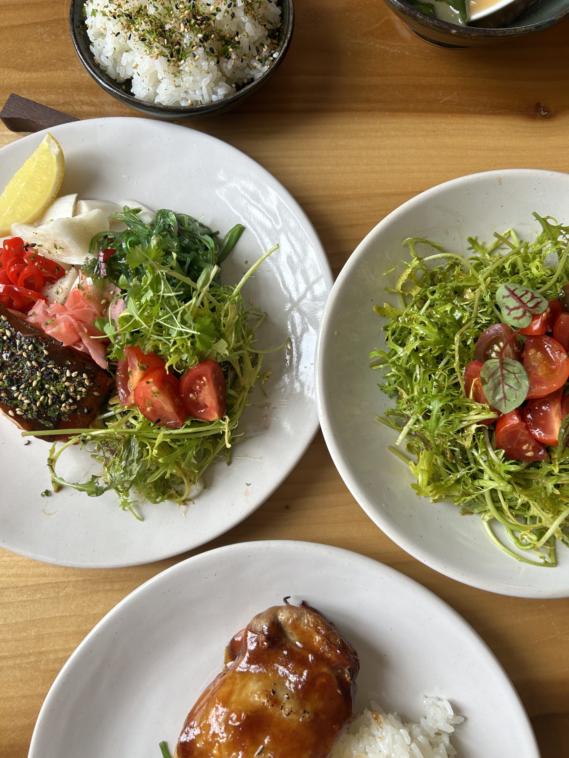 A selection of dishes at Izakaya Inoshishi in Frome including rice topped with furikake, ponzu chicken and salmon.