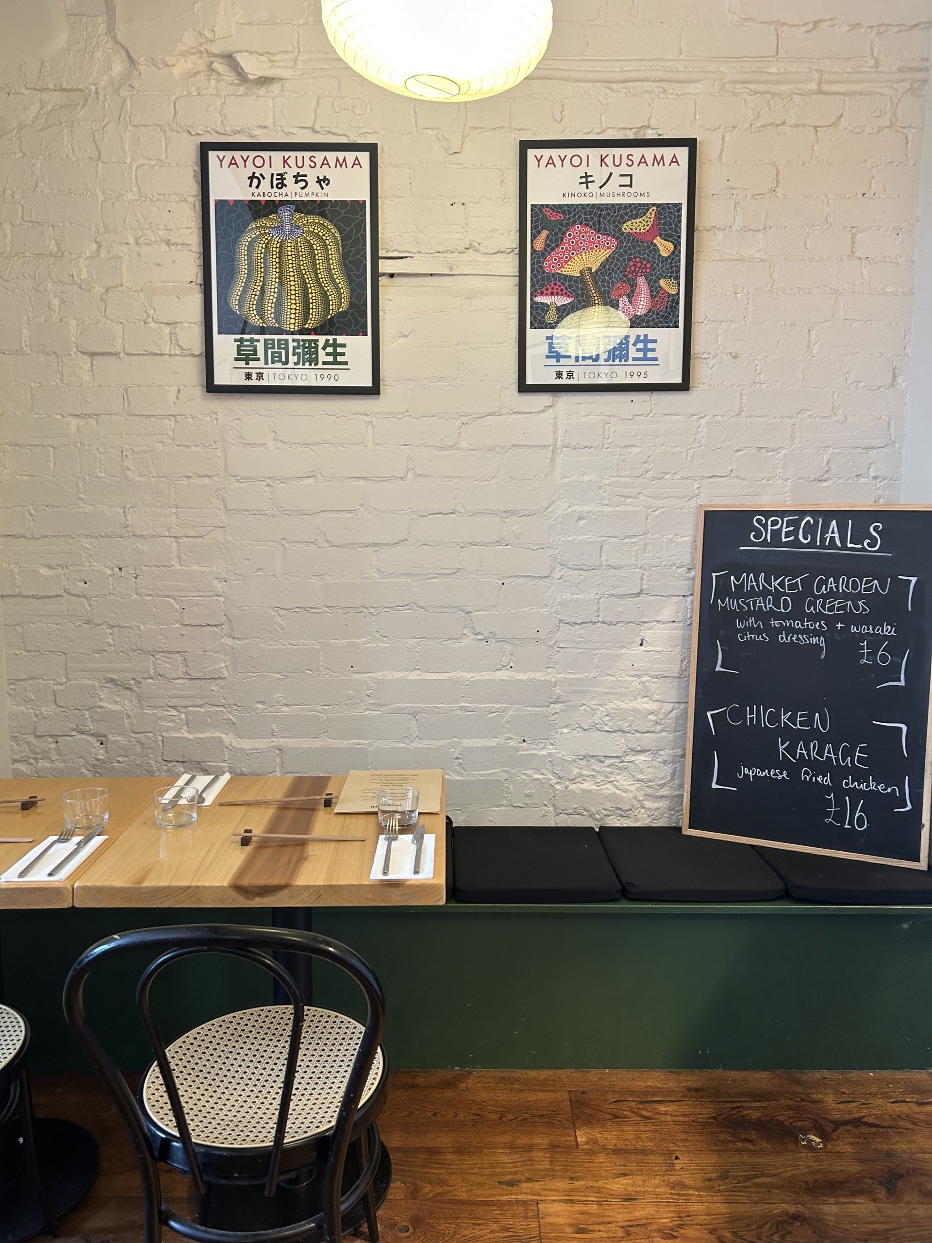 An interior shot of Inoshishi Izakaya in Frome with two Japanese inspired artworks hanging on the wall