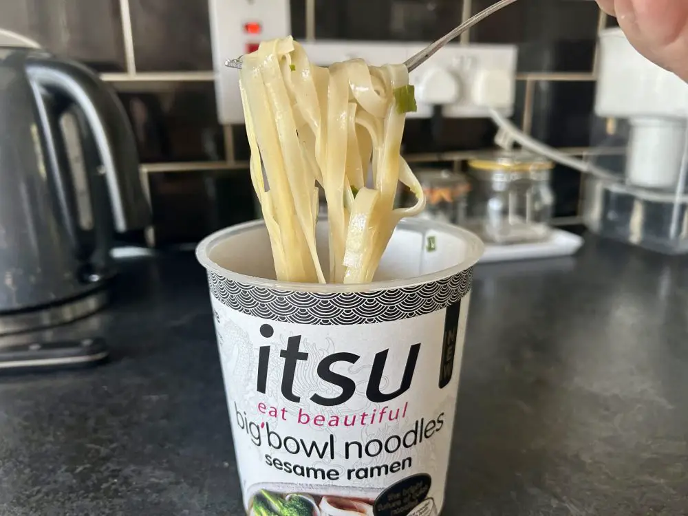 Itsu noodle cup with noodles on a fork