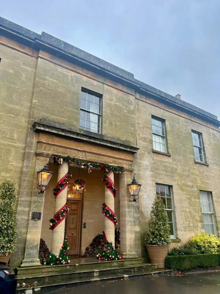 Grand georgian house wth christmas ribbon tied around the pillars infront of the front door