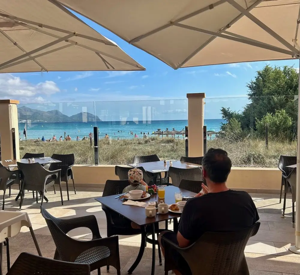 Father and young son sitting at the Green and Grill restaurant at Alcudia Pins hotel in Mallorca