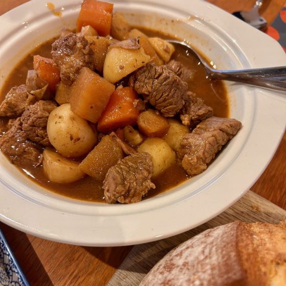 a big bowl of beef stew with carrots and potatoes