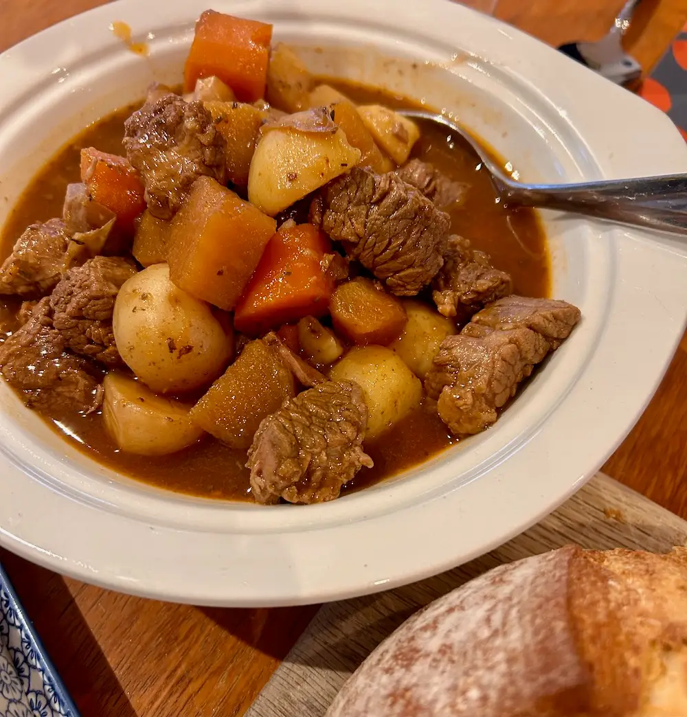 a big bowl of beef stew with carrots and potatoes