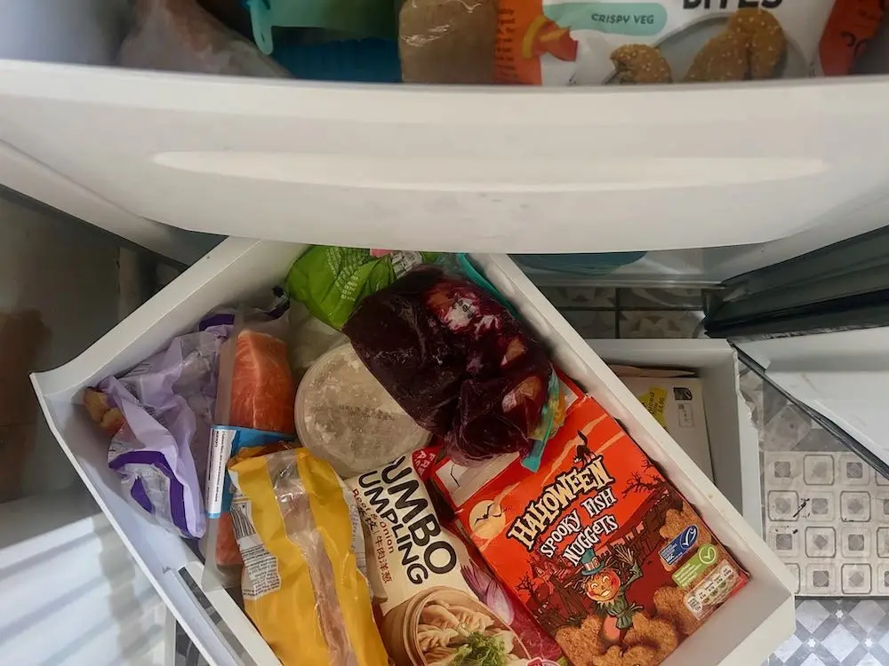 A freezer full of packets and boxes of food.