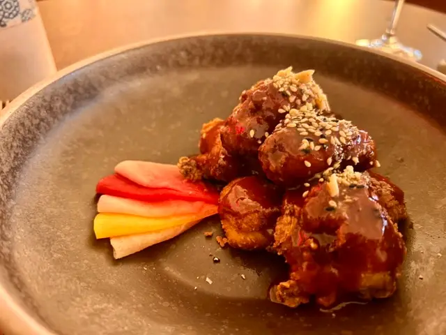 Korean fried chicken with 5 coloured pickled radishes on the plate