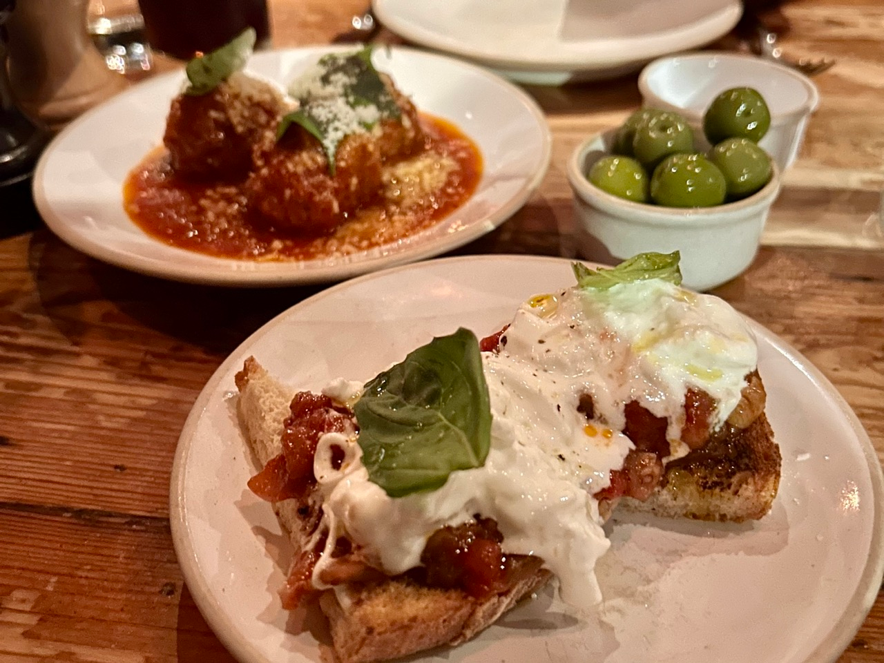 A trio of starters at Flour & Grape in London - meatballs, bruschetta and olives.